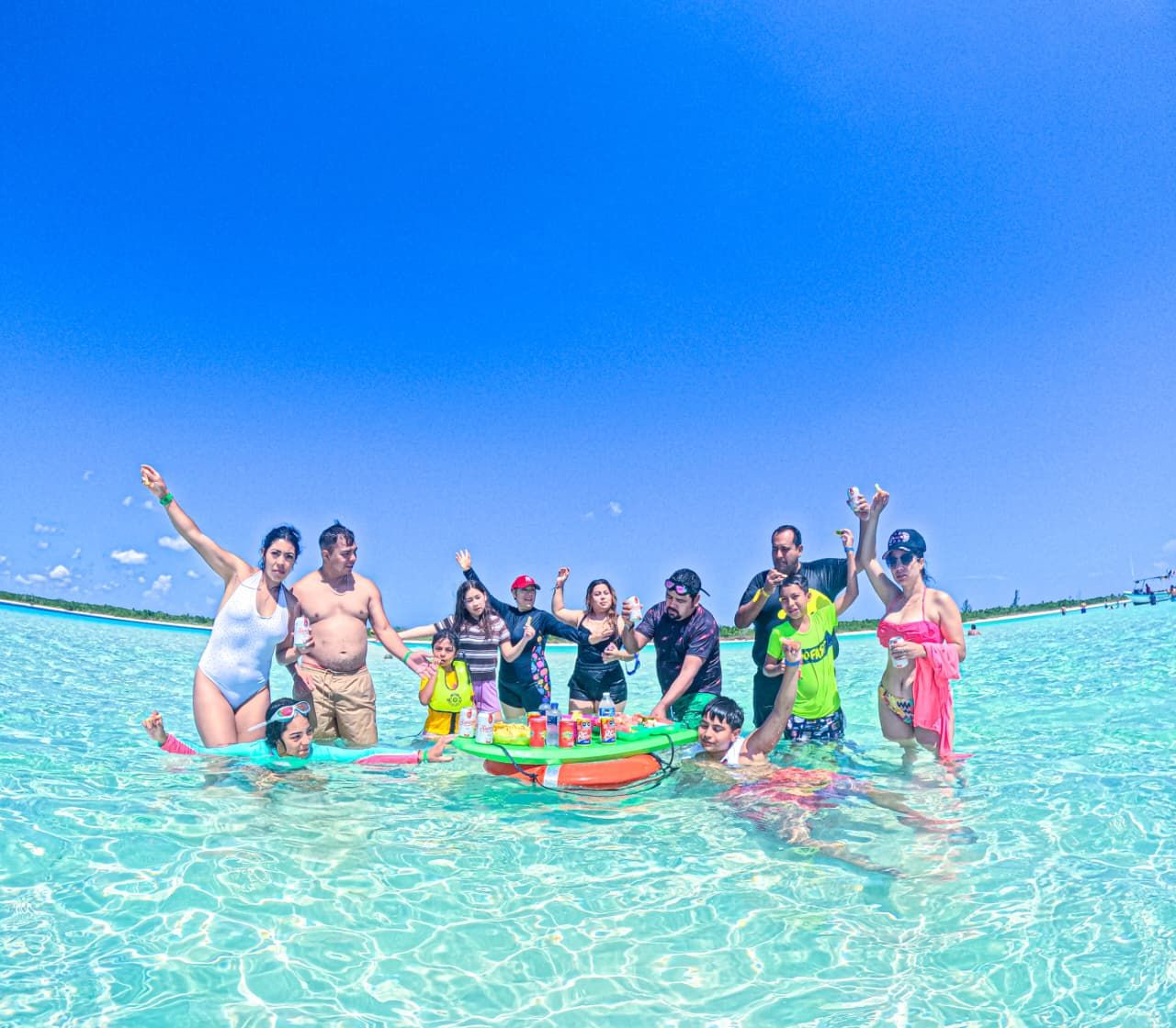 Grupo celebrando junto a un flotador con bebidas y botanas