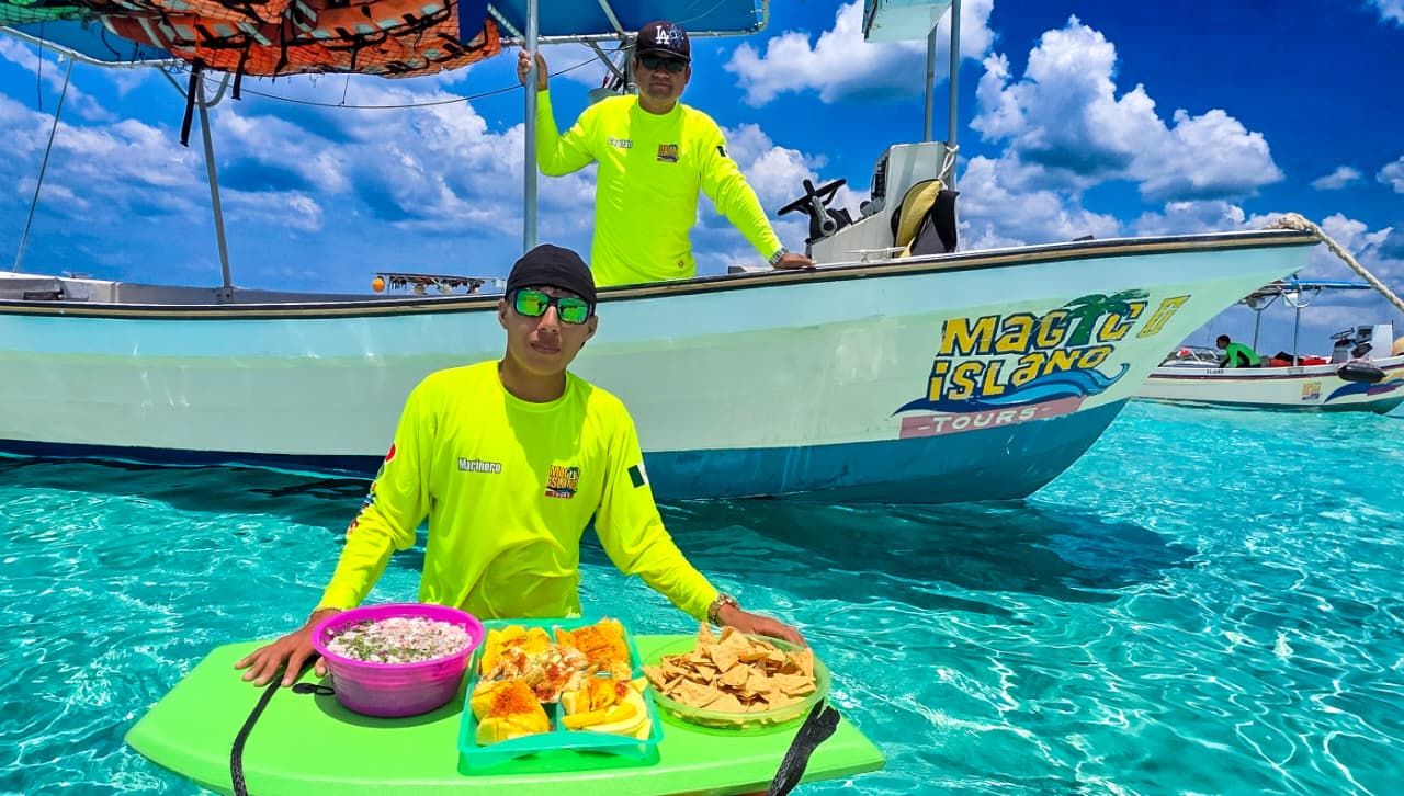 Guía de Magic Island Tours con una tabla flotante de botanas junto a la lancha