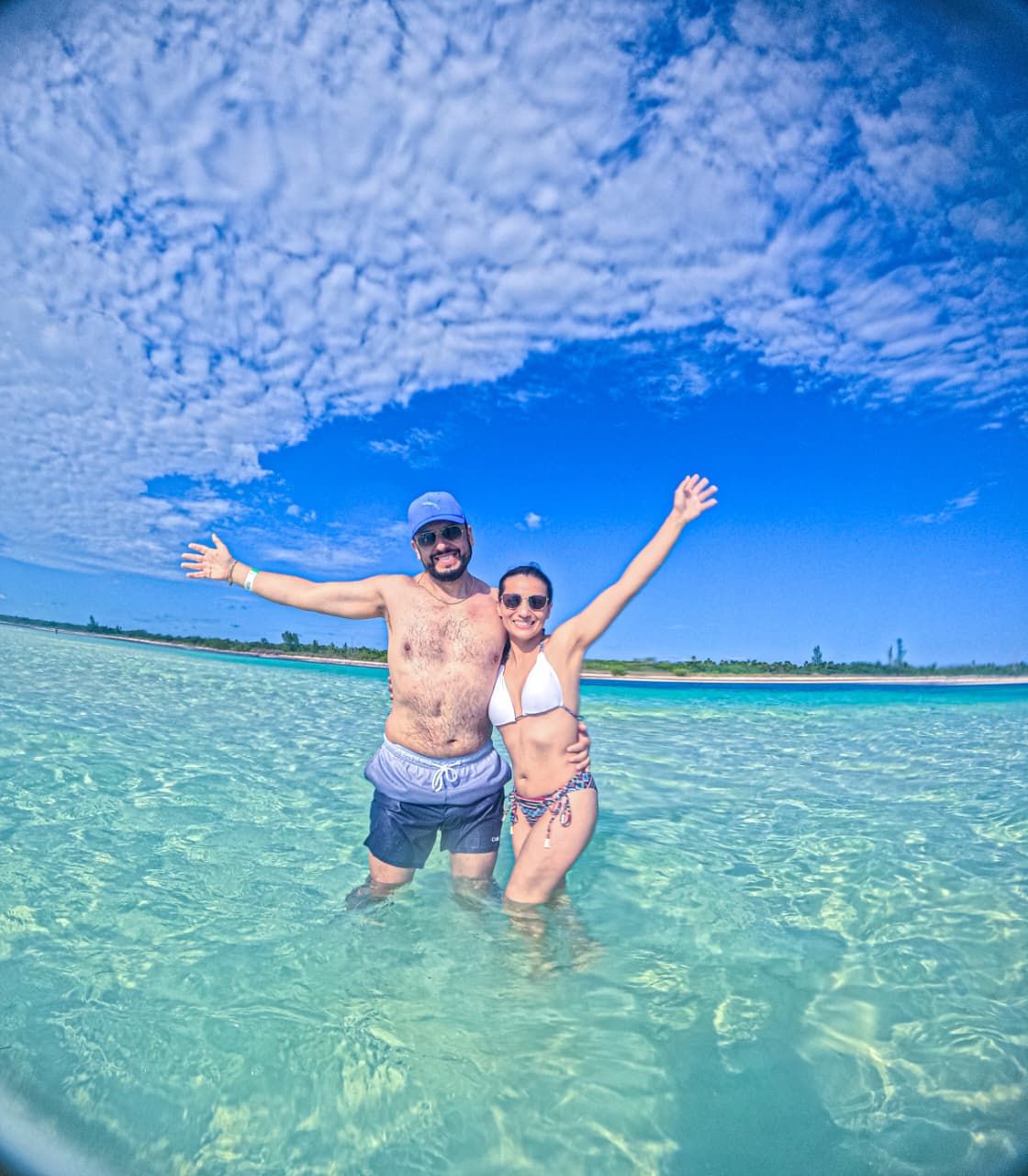 Pareja con los brazos abiertos en aguas poco profundas